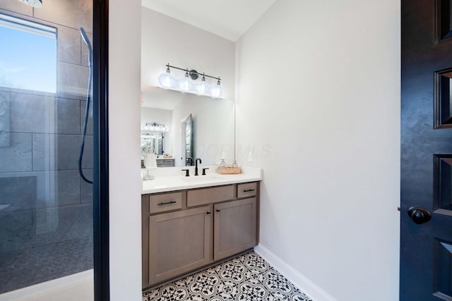 bathroom featuring tile patterned flooring, vanity, and tiled shower