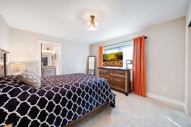 bedroom with ensuite bath and light colored carpet