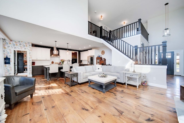 living room featuring light hardwood / wood-style flooring and a high ceiling