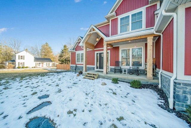 snow covered property featuring covered porch