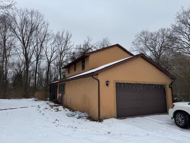 snow covered property featuring a garage