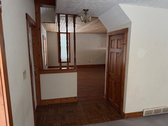 hallway with dark parquet floors and a textured ceiling