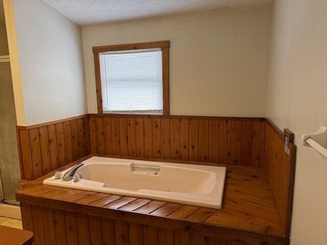 bathroom featuring a tub and a textured ceiling