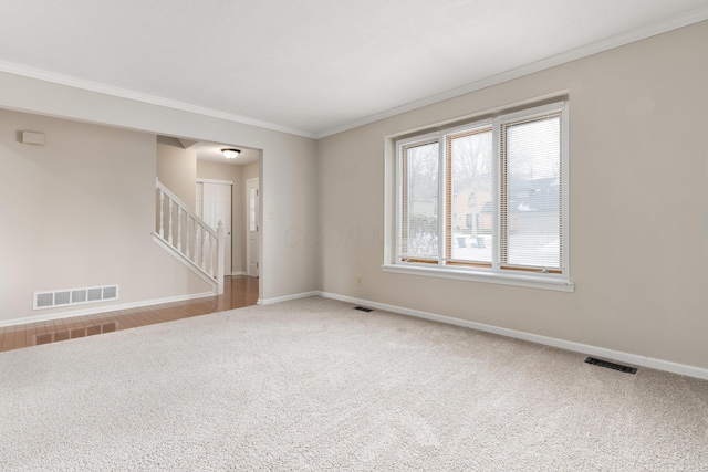 carpeted spare room featuring crown molding