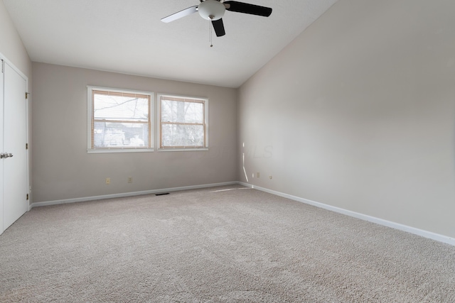 spare room featuring lofted ceiling, carpet floors, and ceiling fan