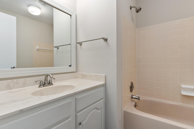 bathroom with vanity and tiled shower / bath combo