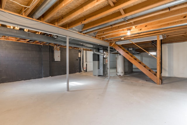 basement with electric panel, heating unit, and gas water heater