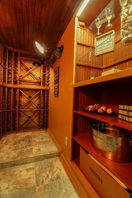 wine room with wood ceiling and wood walls