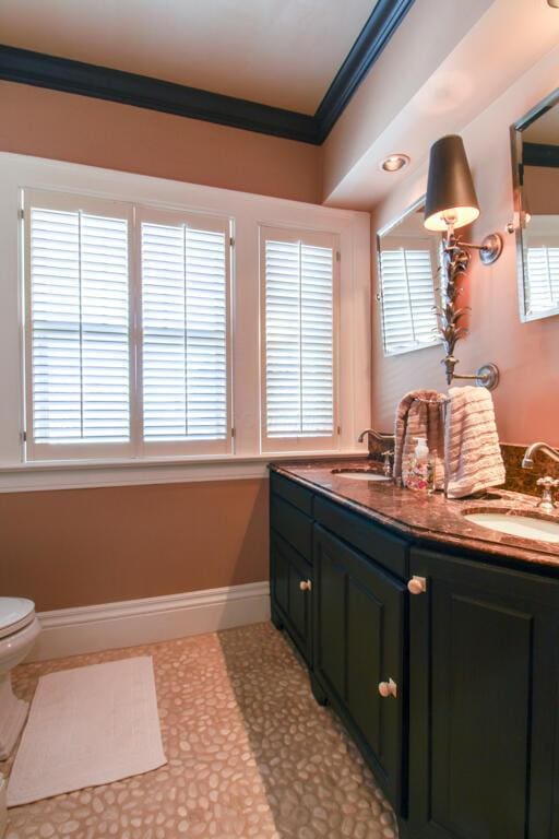 bathroom with vanity, crown molding, toilet, and a healthy amount of sunlight