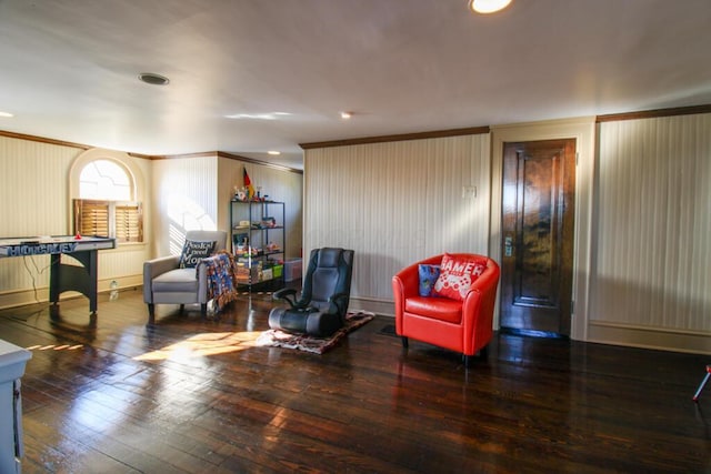 living area with crown molding and dark wood-type flooring