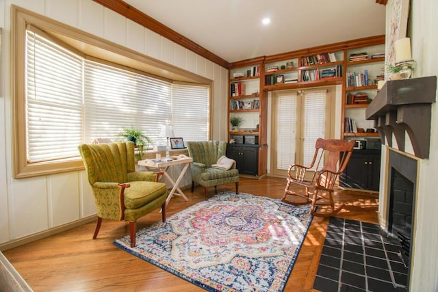 sitting room featuring crown molding, a fireplace, and light hardwood / wood-style floors