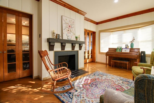 sitting room featuring hardwood / wood-style flooring, ornamental molding, and a tile fireplace