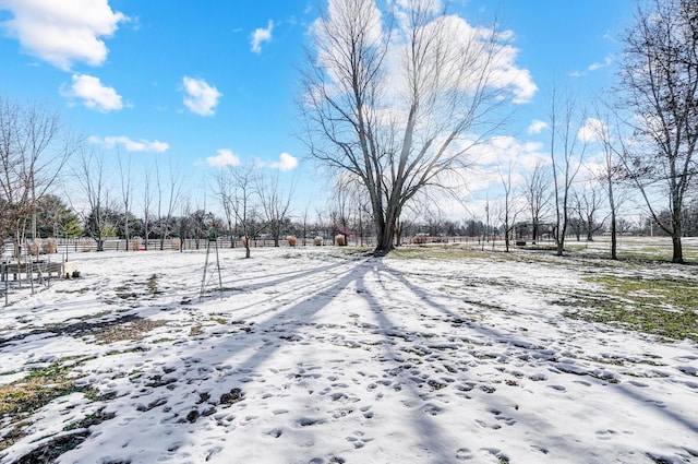 yard covered in snow featuring a rural view