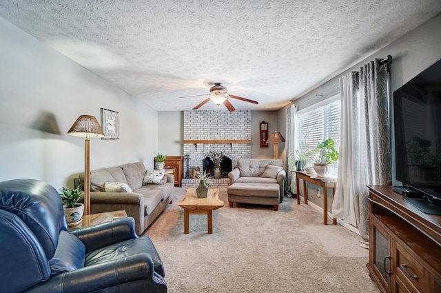 living room featuring ceiling fan, light colored carpet, a textured ceiling, and a fireplace