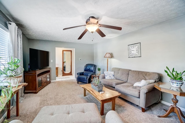 carpeted living room featuring ceiling fan and a textured ceiling