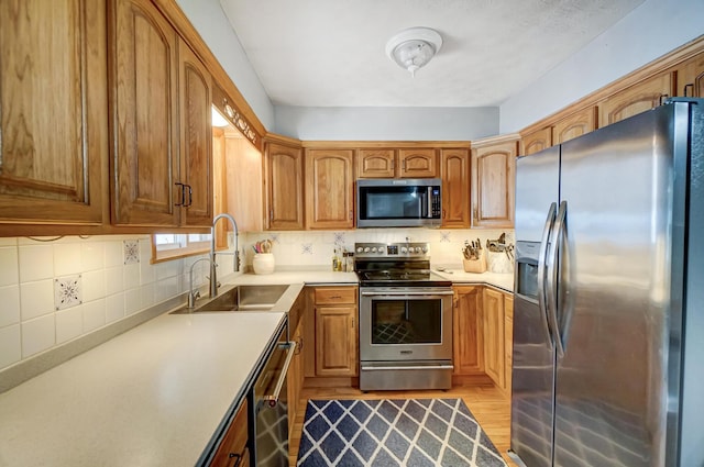 kitchen with tasteful backsplash, stainless steel appliances, light hardwood / wood-style floors, and sink