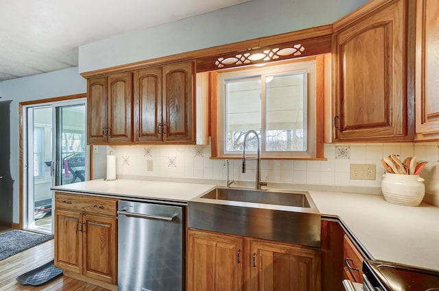 kitchen featuring stainless steel appliances, sink, backsplash, and light wood-type flooring