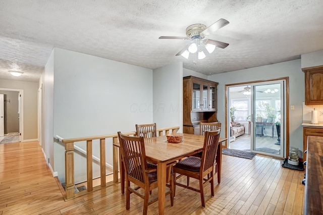 dining area featuring ceiling fan, a textured ceiling, and light wood-type flooring