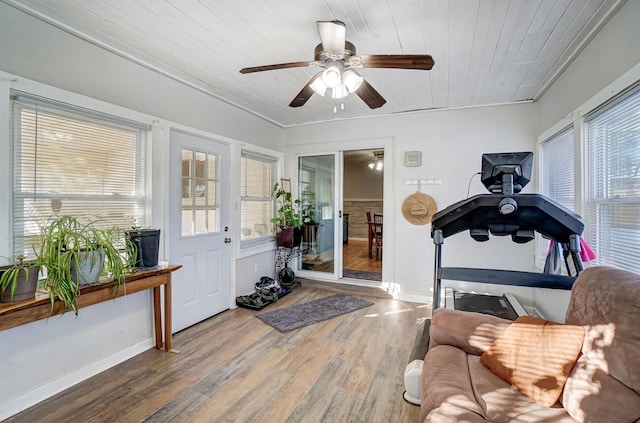 interior space with wood ceiling, wood-type flooring, ornamental molding, and ceiling fan