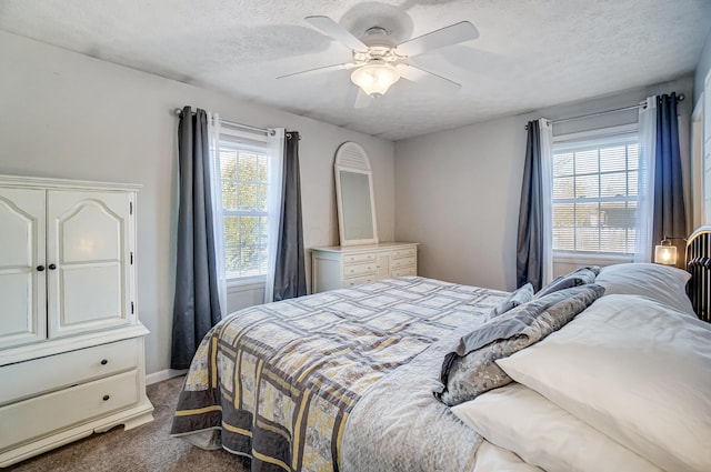 bedroom featuring ceiling fan, a textured ceiling, and dark carpet