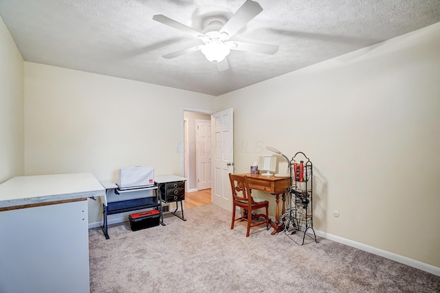 carpeted office featuring a textured ceiling and ceiling fan