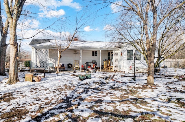 view of snow covered back of property