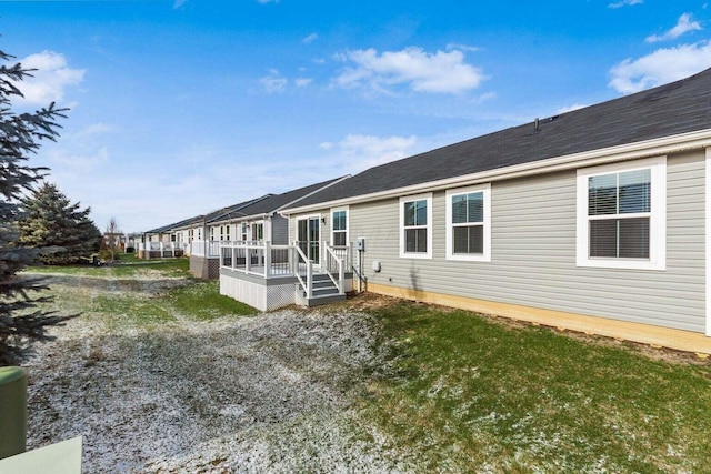 rear view of house with a wooden deck and a yard