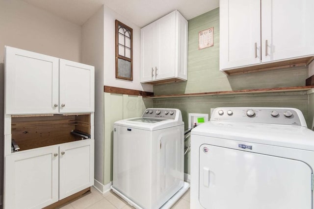 laundry area with light tile patterned flooring, cabinets, and washer and dryer