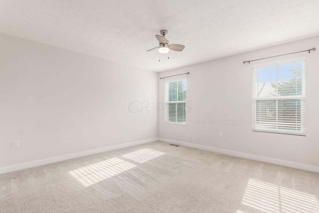 carpeted spare room with ceiling fan and a textured ceiling