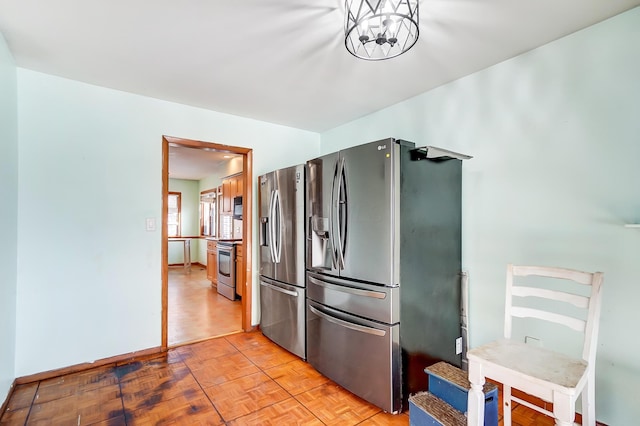 kitchen featuring an inviting chandelier, stainless steel appliances, and light parquet flooring