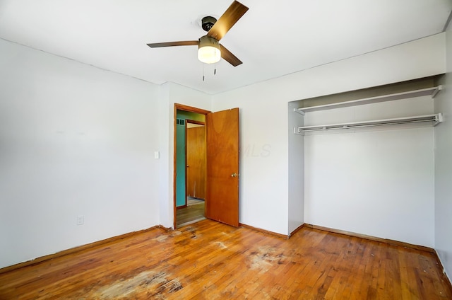 unfurnished bedroom featuring hardwood / wood-style floors, ceiling fan, and a closet