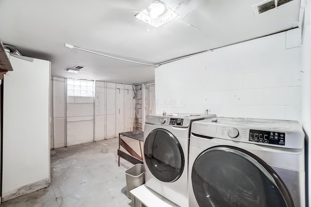 clothes washing area with washing machine and dryer