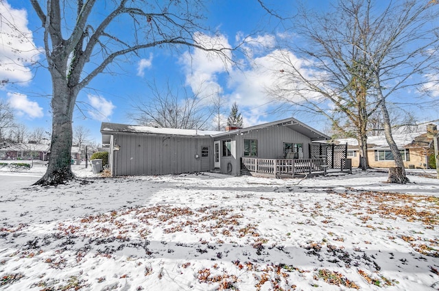 view of snow covered back of property