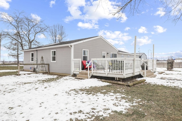 snow covered property featuring a wooden deck