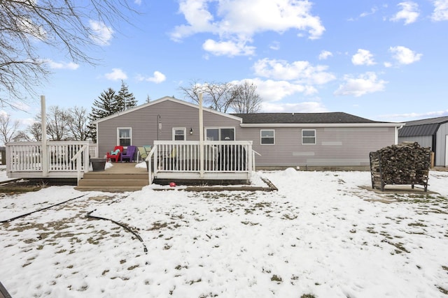 snow covered house featuring a deck