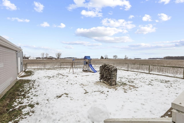 yard layered in snow with a playground