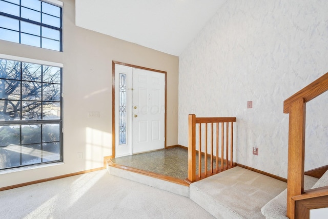 entryway featuring a high ceiling and carpet flooring