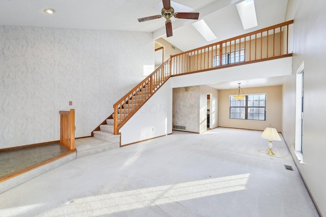 living room featuring a skylight, high vaulted ceiling, ceiling fan, and light colored carpet