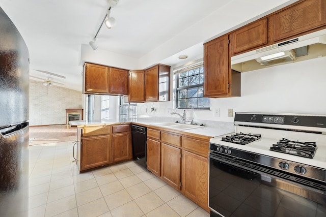 kitchen with kitchen peninsula, sink, light tile patterned flooring, black appliances, and lofted ceiling