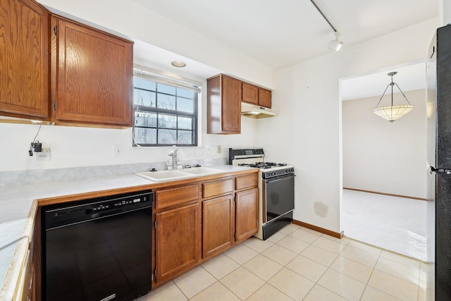 kitchen with sink, decorative light fixtures, light tile patterned floors, track lighting, and black appliances