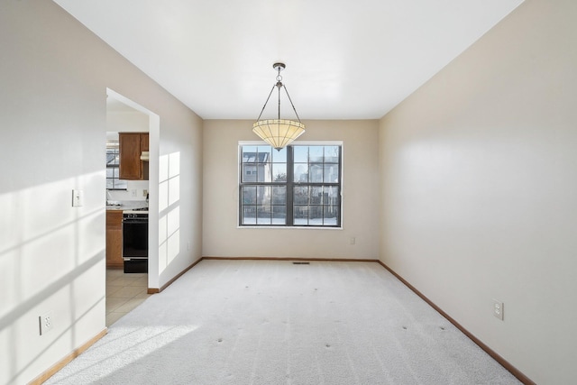 unfurnished dining area featuring light colored carpet