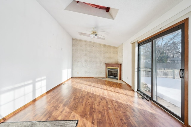 unfurnished living room featuring a fireplace, wood-type flooring, ceiling fan, and vaulted ceiling