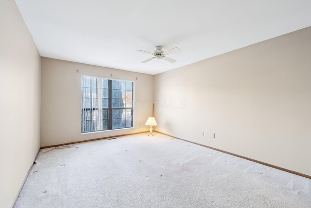 carpeted spare room with ceiling fan