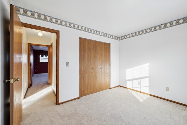 unfurnished bedroom with light colored carpet and a closet