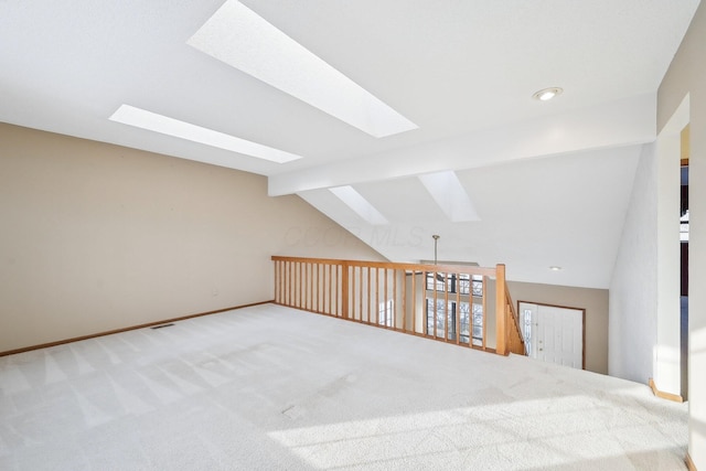 bonus room featuring vaulted ceiling with skylight and carpet floors