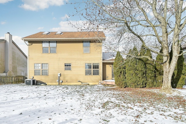 snow covered house featuring central air condition unit