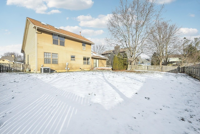 snow covered house with central AC