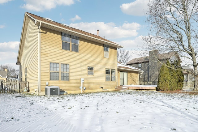 snow covered property with central air condition unit