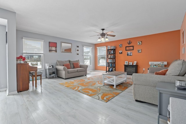 living room with light hardwood / wood-style floors, ceiling fan, and plenty of natural light