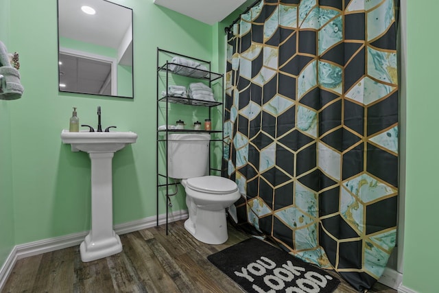 bathroom with a shower, hardwood / wood-style floors, and toilet